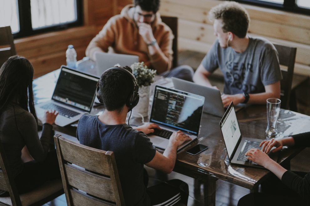 People sitting at desks with laptops
