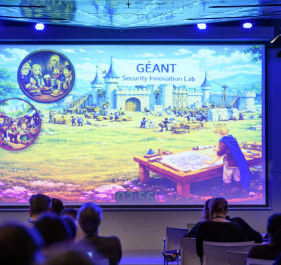 Large conference screen with fairy tale image and man with microphne presenting