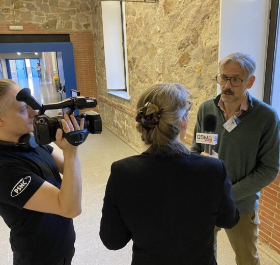 A cameraman, a woman with microphone interviewing a man